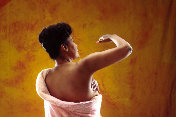 Woman performing breast exam